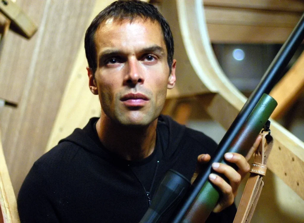 Rudolf Martin as Ari Haswari aiming a sniper rifle in NCIS, causing Kate Todd's shocking death.
